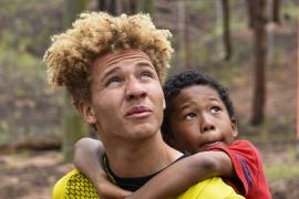 camper hanging on to counselor's shoulders