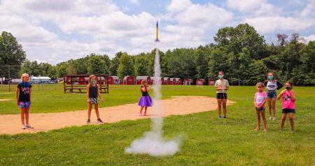 campers in masks launching a rocket