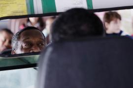 Bus driver looking at kids in rear-view mirror